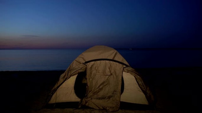 孩子躲在帐篷里时，海岸警卫队用手电筒照明，无家可归的孤儿