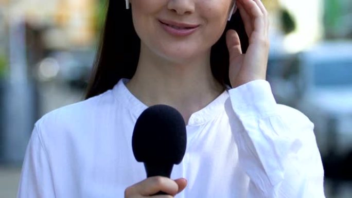 带有麦克风无线耳机的女性新闻播音员，提供新闻，报告文学