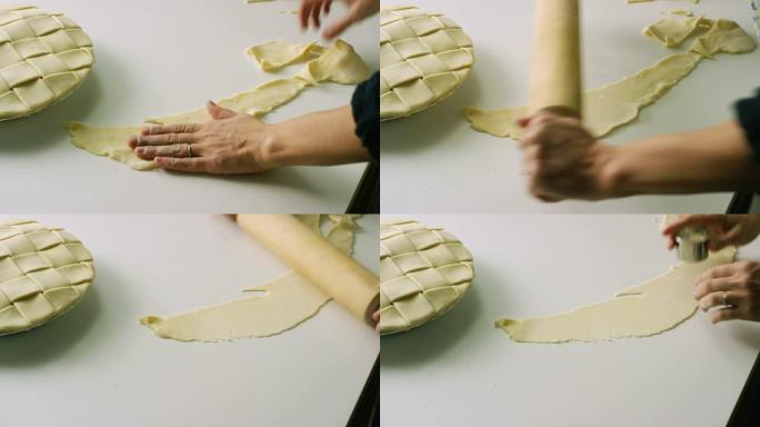 一个女人的手将一个未烘烤的格子馅饼推开，并用木制Rolling面杖将一块碎屑面团滚出，准备用饼干切掉