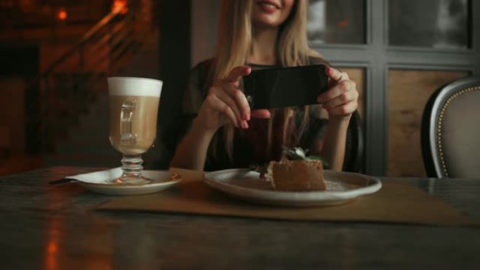 美丽的情感快乐女孩正在制作咖啡馆里的食物照片，桌上的拿铁咖啡，甜点冰淇淋巧克力蛋糕樱桃薄荷，社交网络