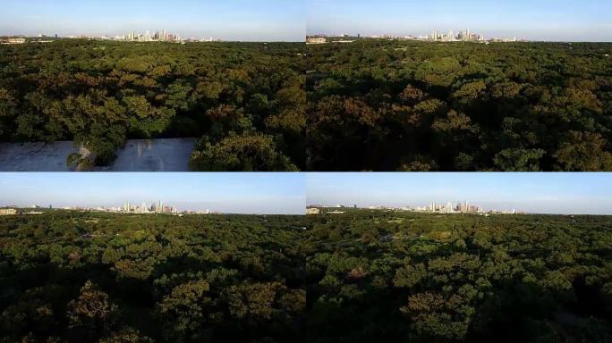 飞越德克萨斯州奥斯汀的绿带，午后阳光的阴影与城市景观天际线背景