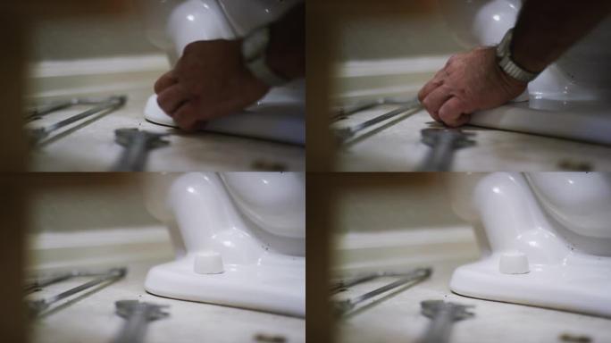 一名高加索修理工在室内家庭浴室中固定马桶时，用塑料螺栓盖覆盖了一个裸露的法兰螺栓