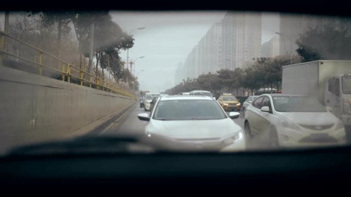 女人在高速公路上行驶，从汽车后窗观察