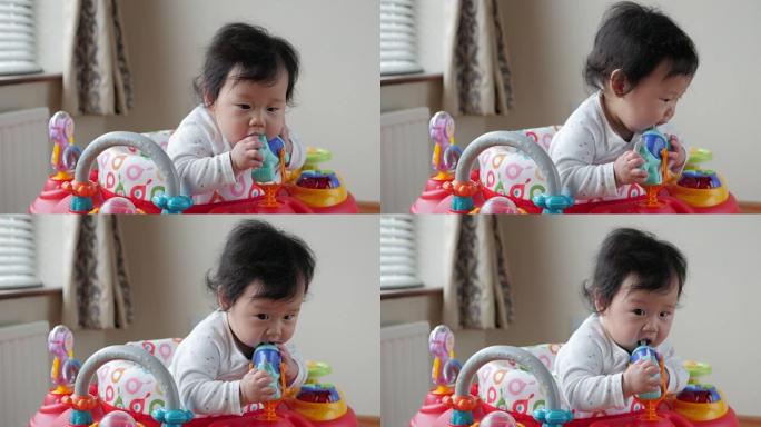 长牙的女婴玩玩具玩玩具的小孩子初生儿喝水