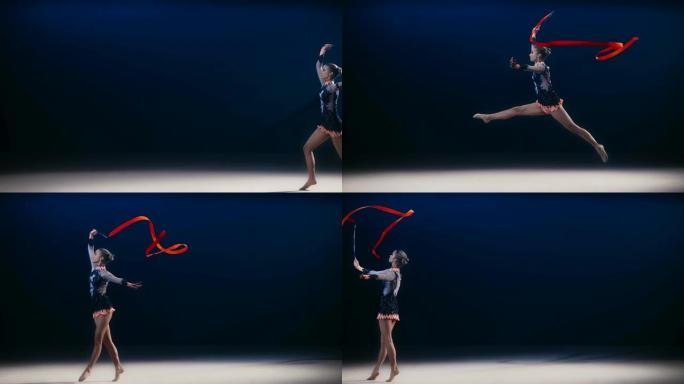 SLO MO艺术体操运动员带着红丝带在地板上奔跑，进行了一次跳跃