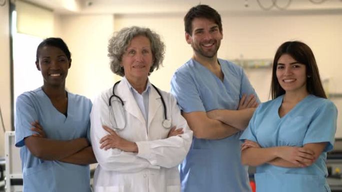 多元化的治疗师和骨科医生团队面对镜头，双臂交叉微笑