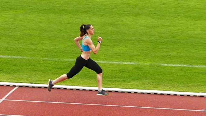 年轻女运动员在跑道慢动作视频上的训练