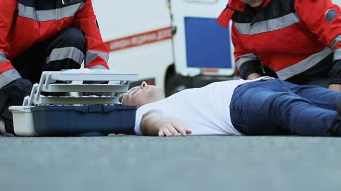 救护人员挽救了躺在路上的男性患者，医生设置了滴管