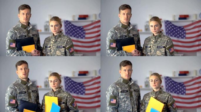 男女美国军事学生拿着文件夹看摄像教育
