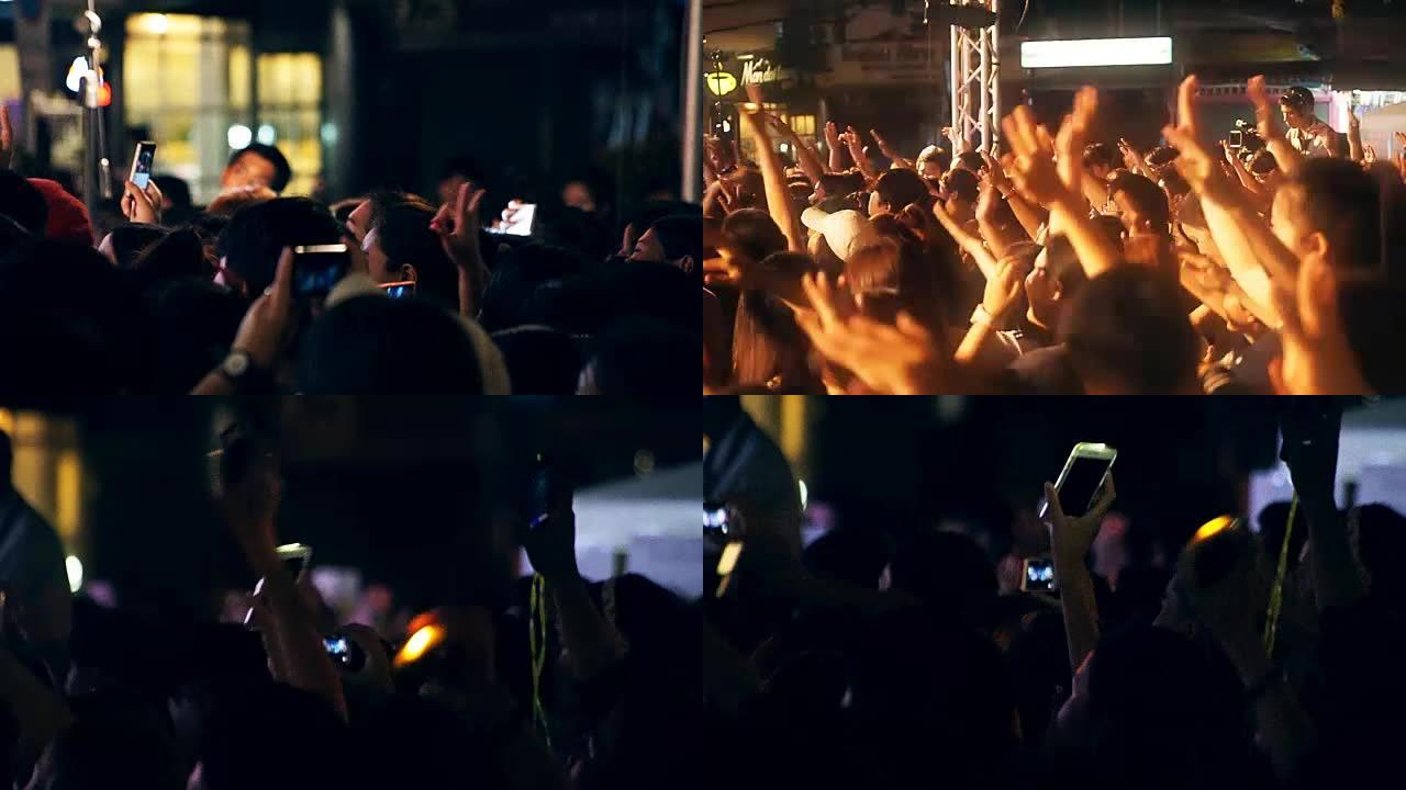 3镜头人群举起手臂跳舞，手持智能手机在音乐会上欣赏。