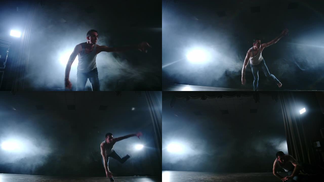 一个现代芭蕾舞，一个男人在黑暗的背景上，在聚光灯和烟雾的灯光下表演跳跃和旋转。杂技编舞，现代芭蕾剧本