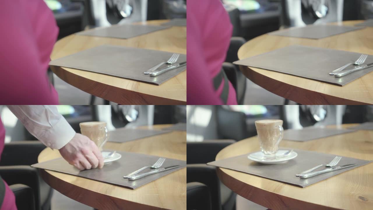 女人在咖啡馆或餐厅等着点菜，服务员在一个漂亮的杯子里拿了一杯卡布奇诺。
