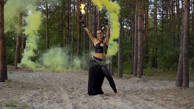 狂野的女人正在用火棍和烟雾弹跳舞