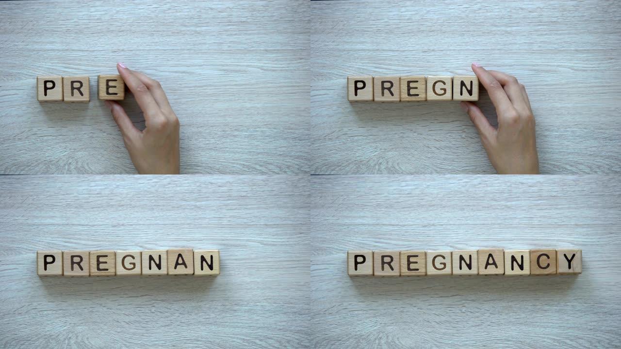 怀孕，在木方块上手写单词，计划生育和儿童