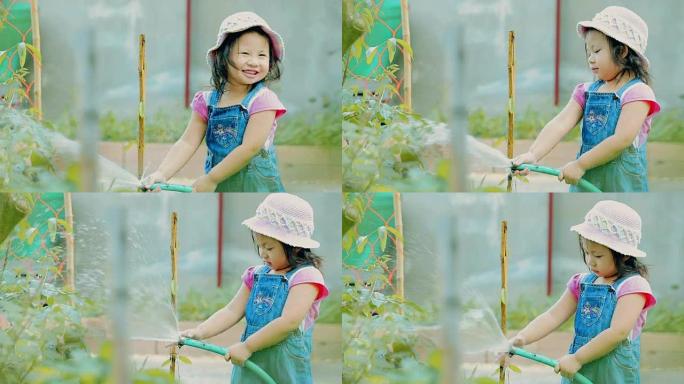 快乐的小女孩在花园里浇水植物 \ \ 概念: 照顾自然