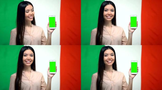 女孩显示绿屏手机，背景上有意大利国旗，翻译