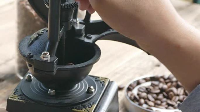 咖啡爱好者把咖啡豆放在旧研磨机上