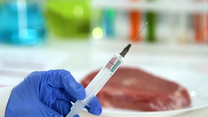 实验室工作人员在肉块上注射农药，防腐剂，转基因生物
