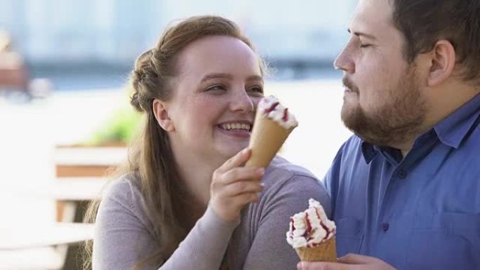 调情的年轻女子用冰淇淋抚摸男朋友的鼻子，顽皮的心情