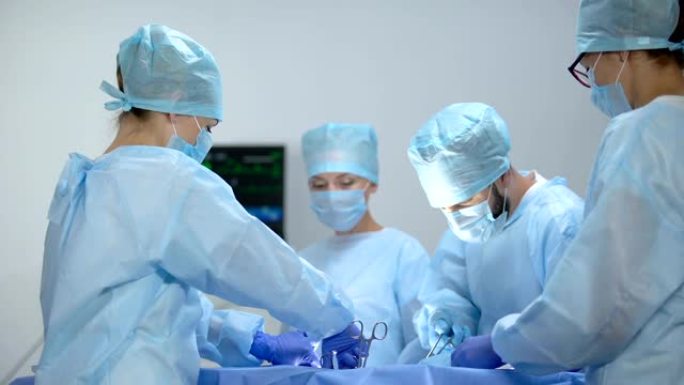 护士在监护仪上查看心率，外科医生团队进行侵入性操作