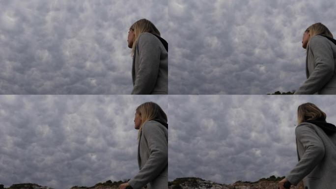 年轻女子的低空视图，上面有构图的云层