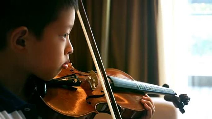 亚洲男孩在家拉小提琴