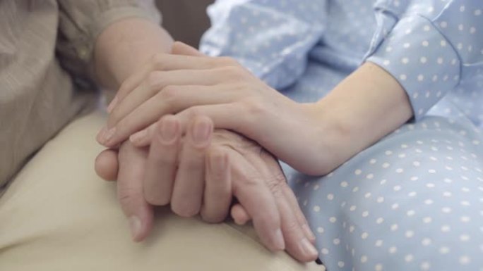 女性牵着老母亲的手，养老院老人护理，家庭支持