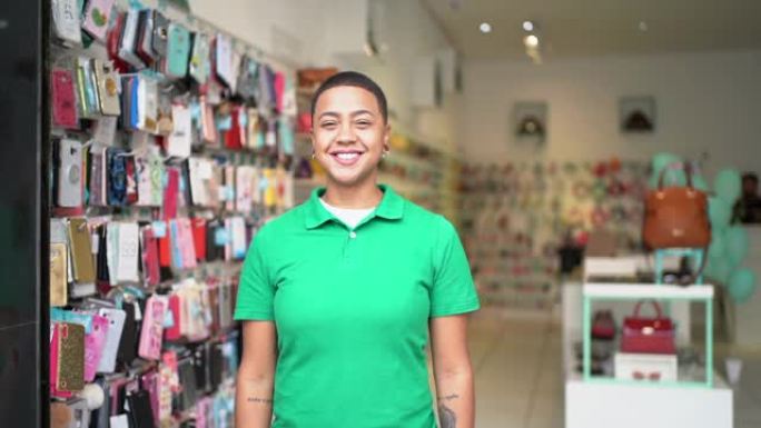 一个年轻的企业主的肖像，双臂交叉站在商店里
