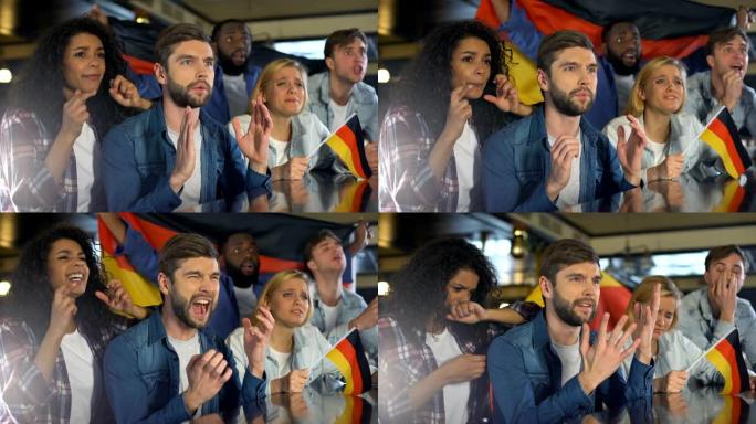 球迷挥舞着德国国旗，在酒吧观看体育节目，对输掉比赛感到不安