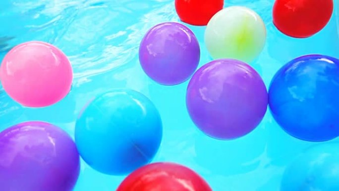超级慢动作高清: 泳池里的彩球。