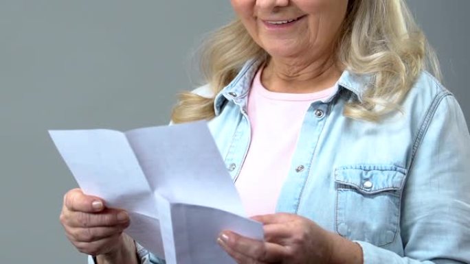 快乐的奶奶手里拿着信封读书信，书信，新闻