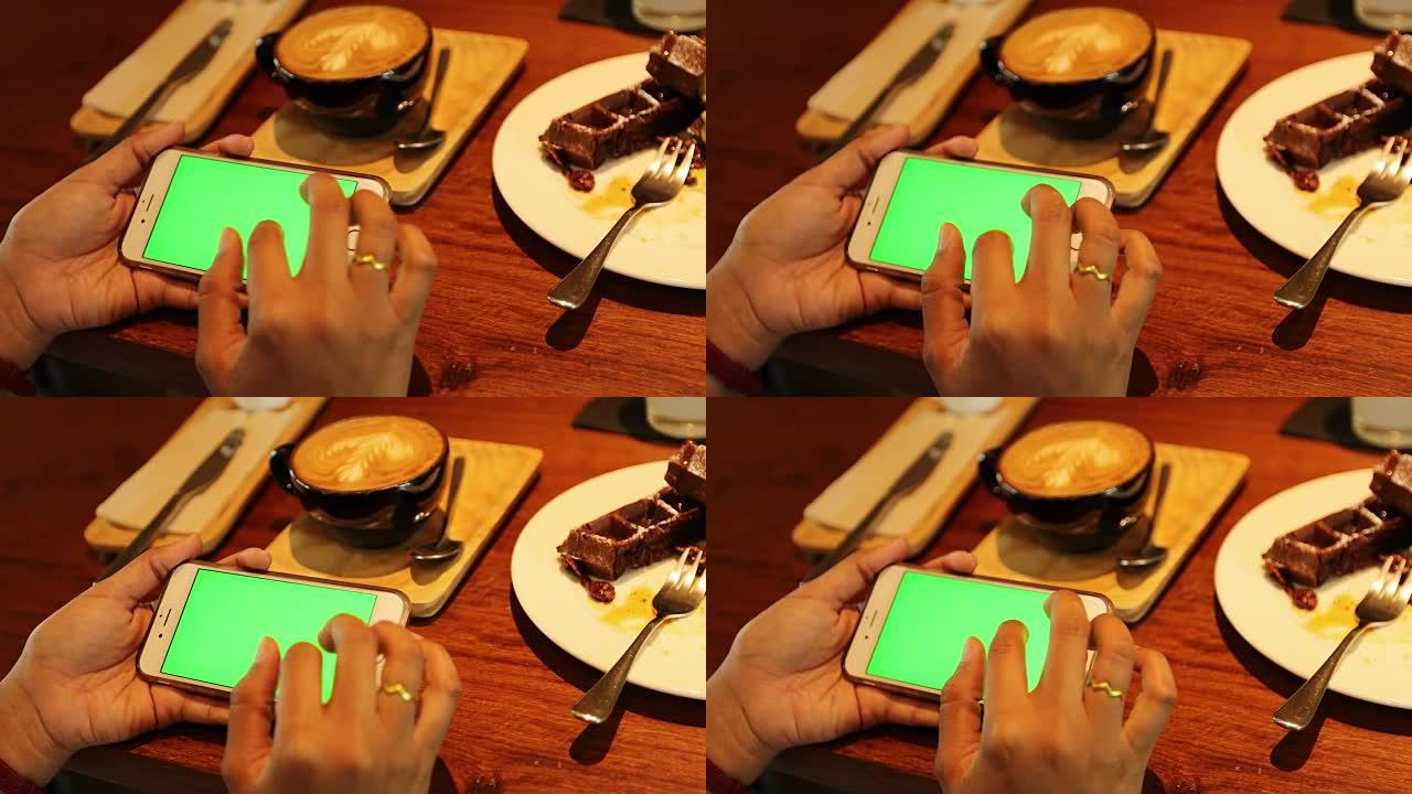 女人在咖啡店使用带有绿屏的电话