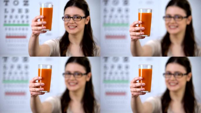 戴着眼镜的女人展示玻璃上的胡萝卜汁，β-胡萝卜素，维生素