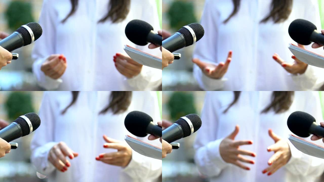 记者手持麦克风采访着名女人的手势，新闻