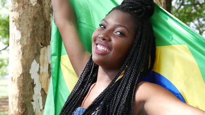 巴西年轻女子举着国旗在公园