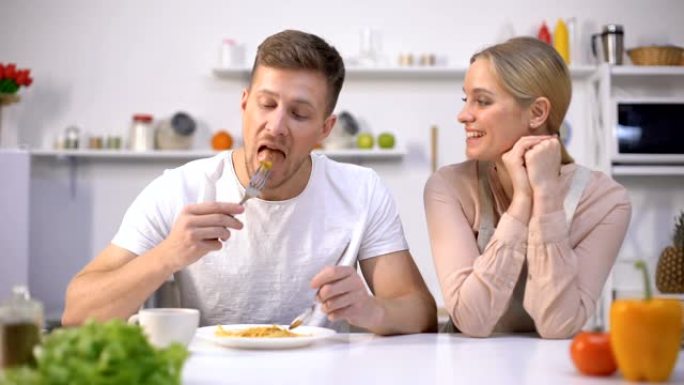 男人假装和快乐的妻子一起吃饭，没有食欲，夫妻关系