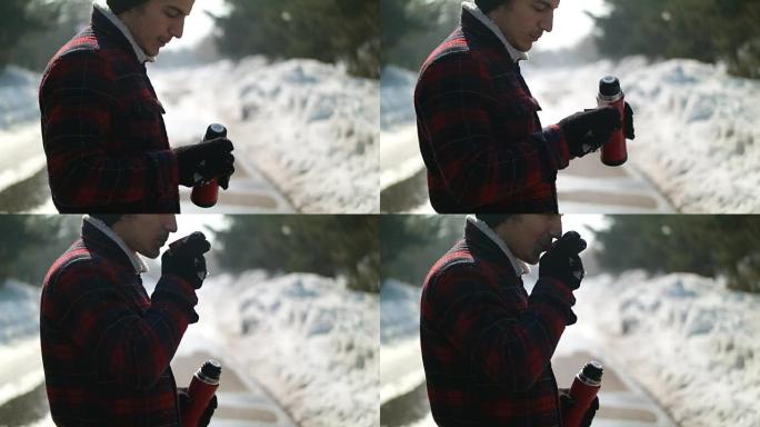 Man pours tea from a thermos winter