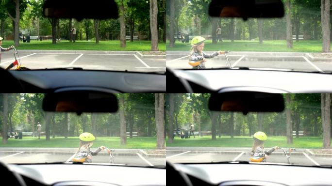漫不经心的小女孩骑着自行车横穿马路，无视汽车，有发生事故的危险