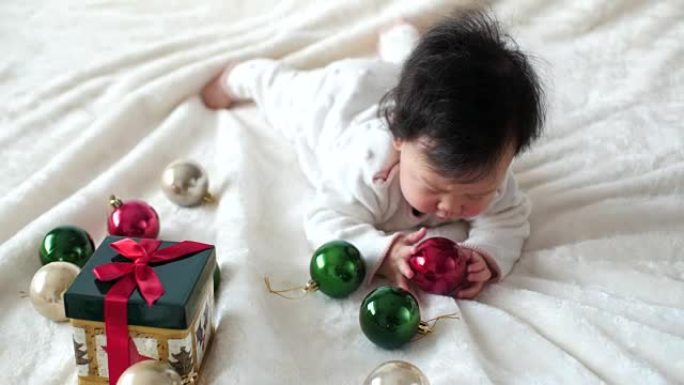 亚洲女婴玩圣诞小摆设和礼品盒