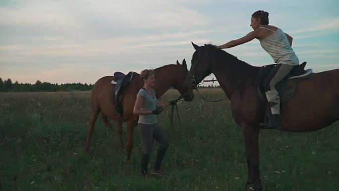 两个女孩带着马在球场上