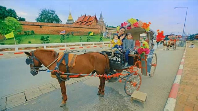 在泰国南邦的phrathi Lampang Luang寺庙享受马车之旅的家庭