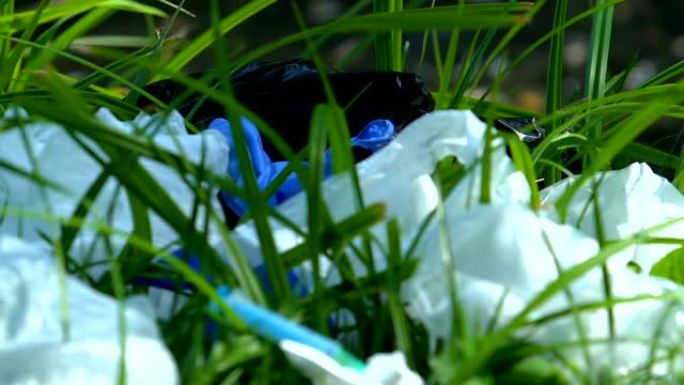 注射器躺在绿草的垃圾填埋场，危险的医疗一次性用品，废物