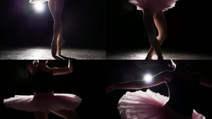 漂亮年轻优雅的芭蕾舞演员在工作室的黑色背景下，在她的尖头芭蕾舞鞋上跳舞。女人穿着芭蕾舞短裙和尖头鞋展