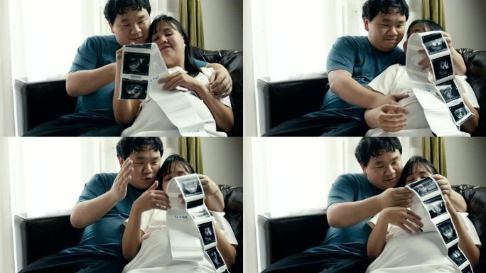 幸福怀孕夫妇看3D超声波扫描照片