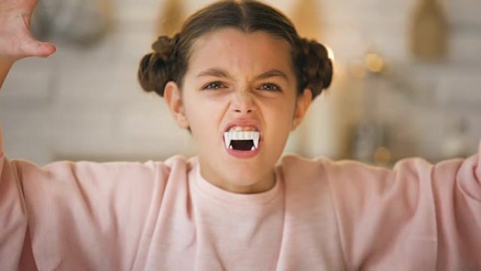大毒牙的吸血鬼小女孩在万圣节派对上做着可怕的脸