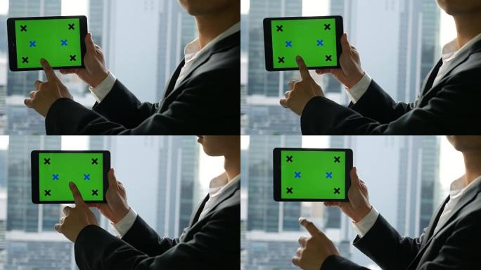 商人拿着绿屏数字平板电脑