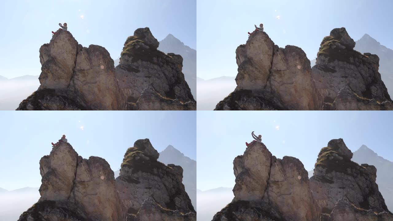 女登山者从山顶或岩石顶峰拍摄自拍照片