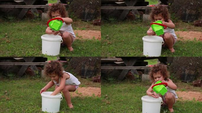 孩子从水桶里倒水到水桶里