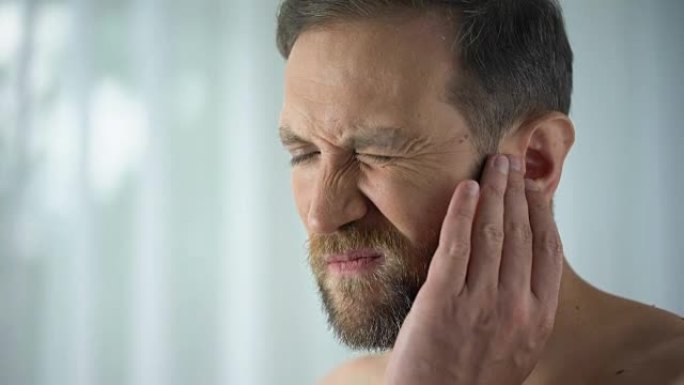 男性患有牙痛、触摸脸颊、牙髓炎症、牙龈炎