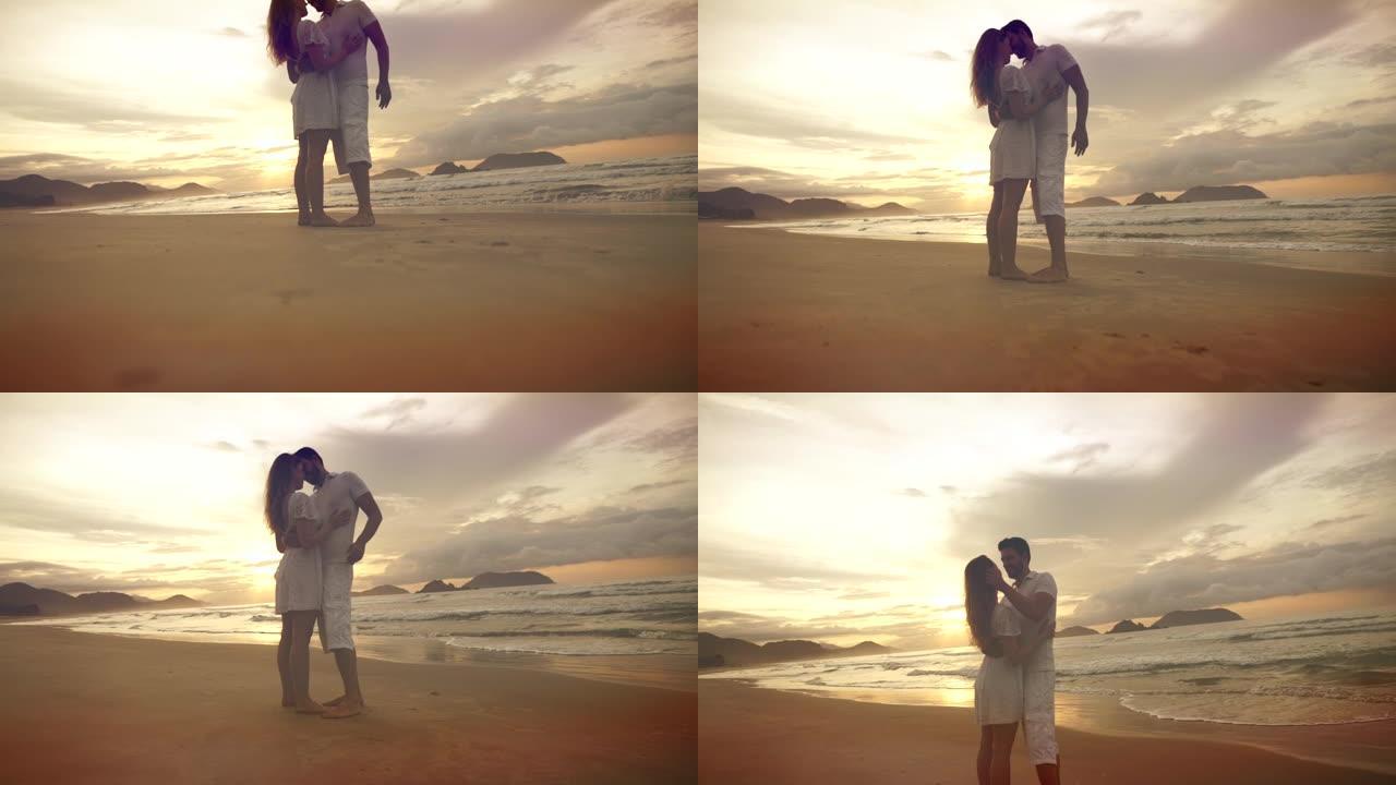 浪漫的情侣在海滩上，背景是五颜六色的日出